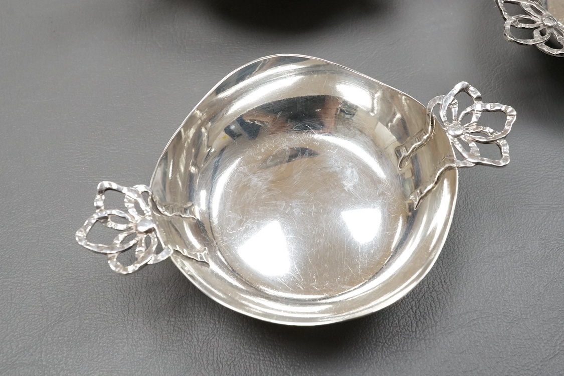 An Edwardian Art Nouveau planished silver tri-handled bowl by Charles Edwards, London, 1905, with stylised handles, diameter 94mm excluding handles, together with a pair of later silver two handled bonbon dishes, Deakin